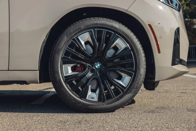 Close-up of a BMW car wheel with sleek alloy design and performance tire. Close-up of a BMW car wheel with sleek alloy design and performance tire.