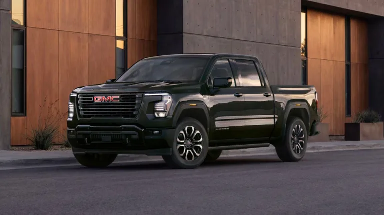 Image 8: front three quarter view, black pickup truck parked on city street beside modern concrete building at dusk.