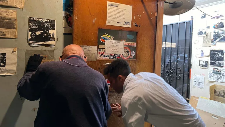 a group of men looking at a poster on the wall a group of men looking at a poster on the wall