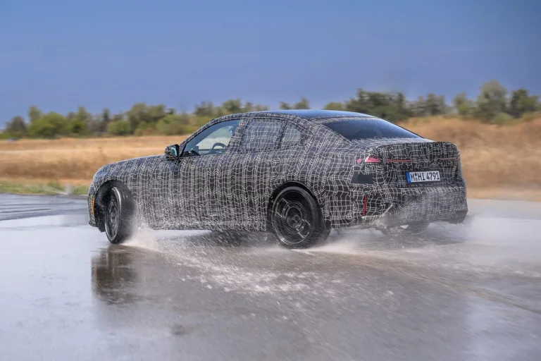Test vehicle maneuvering on wet pavement with camouflage covering. Test vehicle maneuvering on wet pavement with camouflage covering.