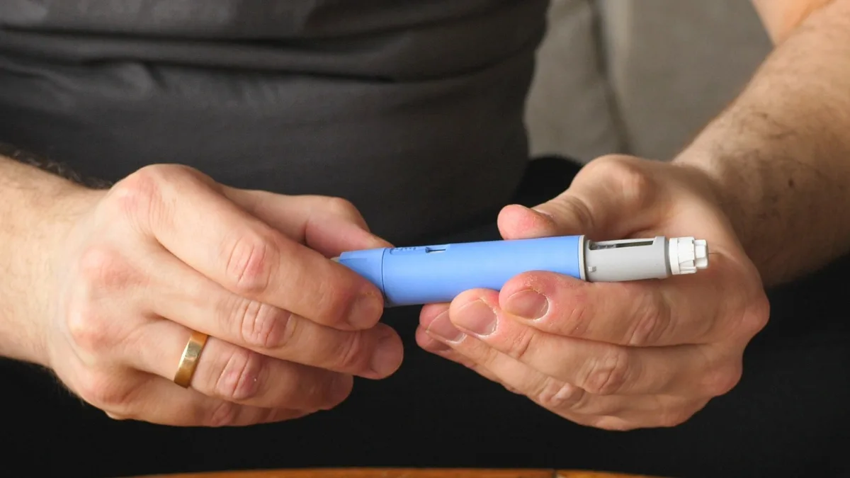 Hands holding a semaglutide pen Semaglutide promotes weight loss by reducing appetite. (imyskin/Canva)