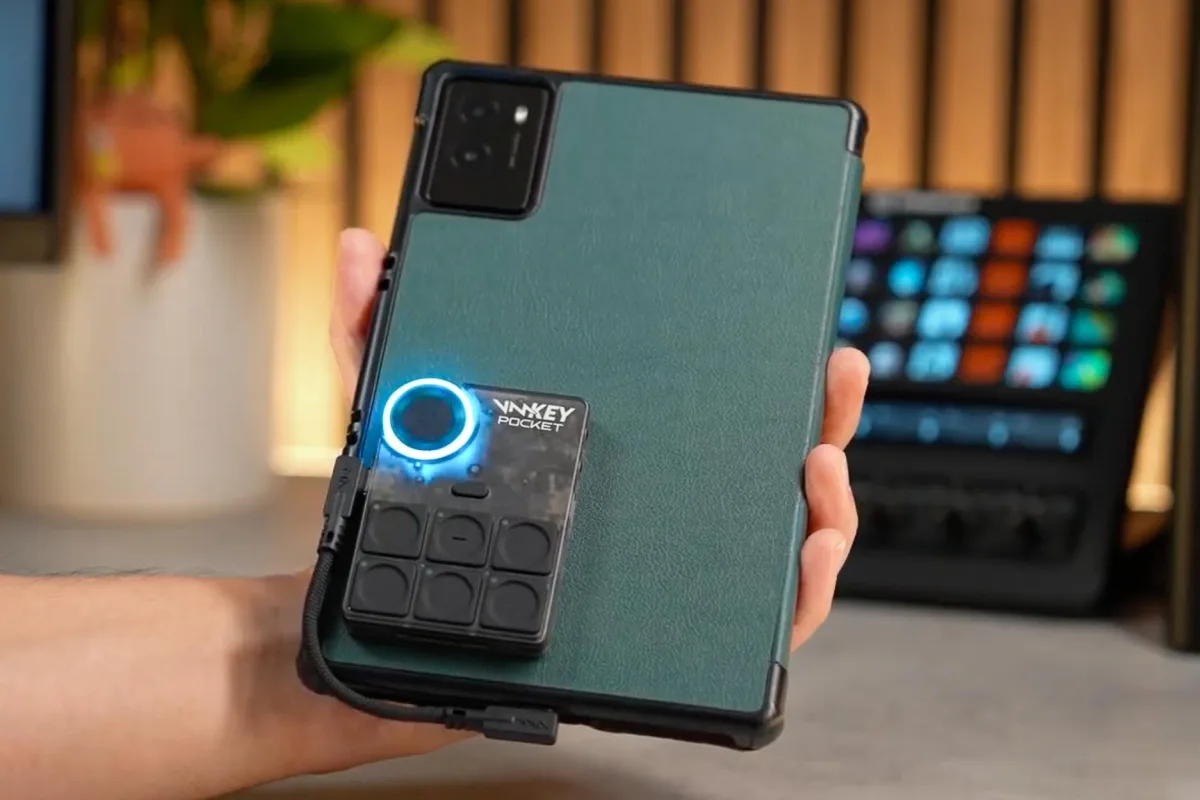 Image 7: The Voicemod Key Pocket connected and attached to the back of a tablet.