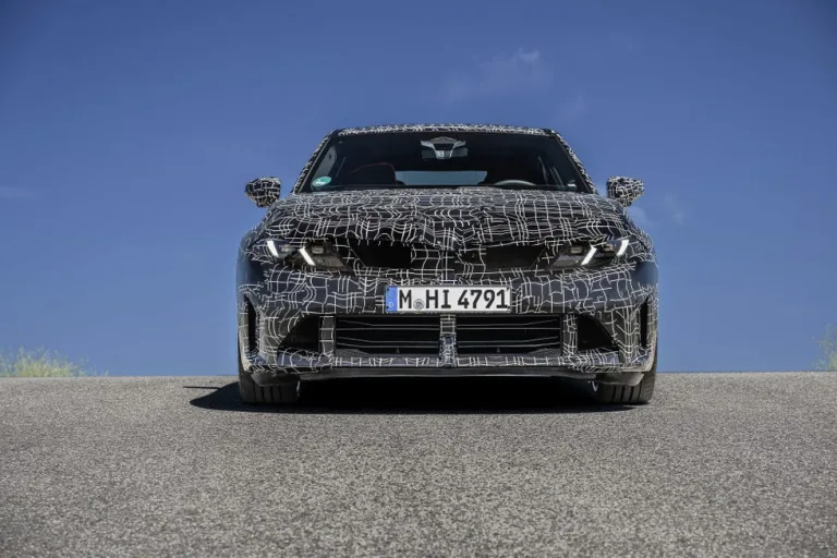 Front view of a camouflaged car on a road with a clear blue sky. Front view of a camouflaged car on a road with a clear blue sky.