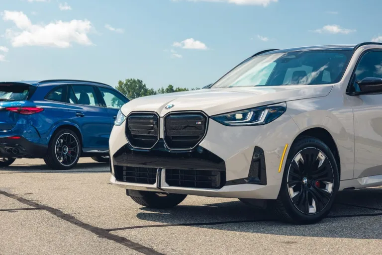 Two BMW vehicles parked on an outdoor asphalt surface under a clear blue sky. Two BMW vehicles parked on an outdoor asphalt surface under a clear blue sky.