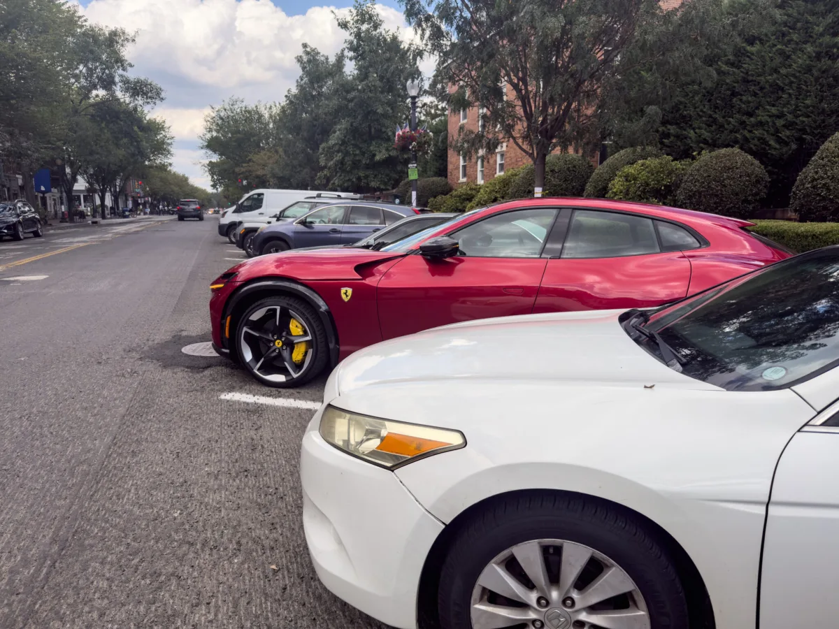 A Ferrari Purosangue parked along with other cars on a road under construction.