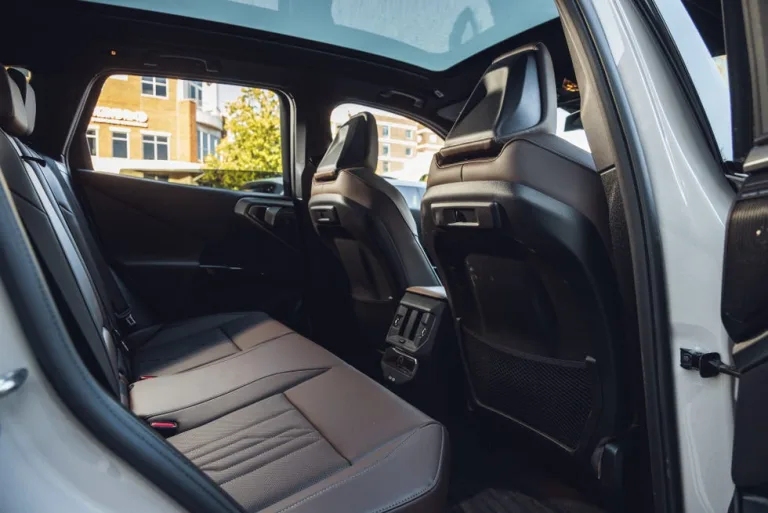Interior view of a vehicle's backseat, showcasing seating and a panoramic sunroof. Interior view of a vehicle's backseat, showcasing seating and a panoramic sunroof.