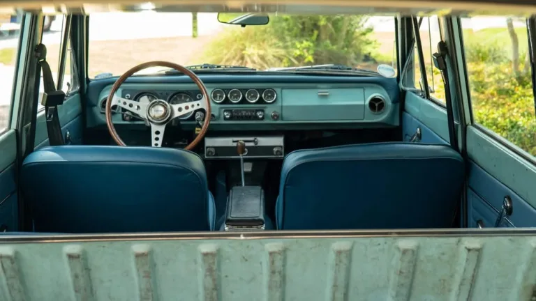 Interior view of a vintage vehicle with blue seats and a wooden steering wheel. Interior view of a vintage vehicle with blue seats and a wooden steering wheel.