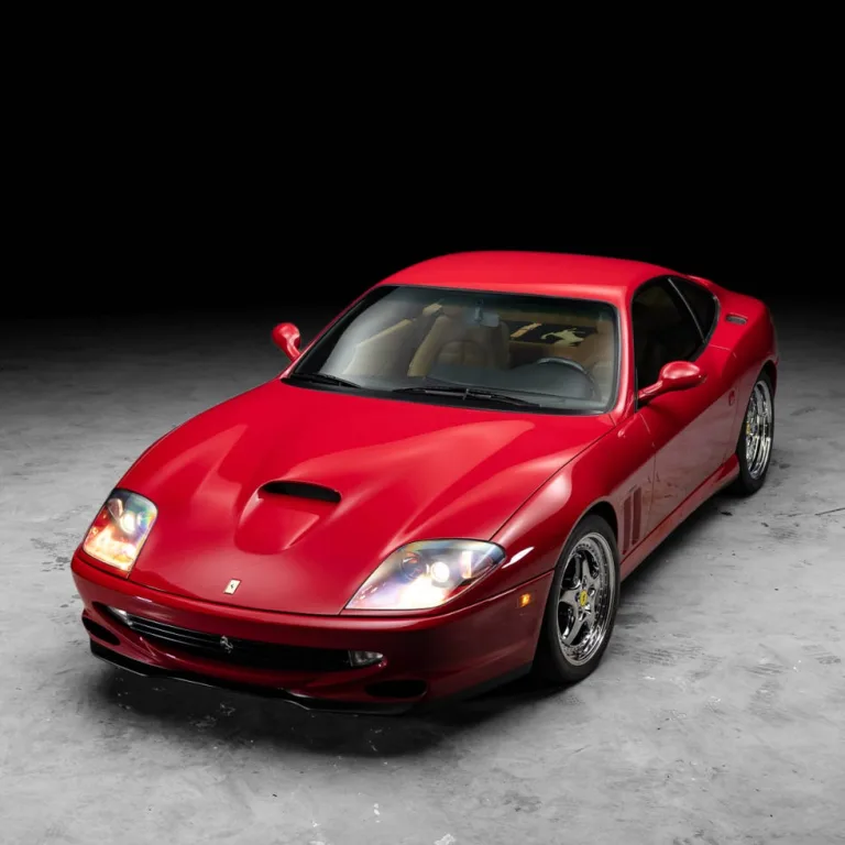 Red sports car with sleek design parked in a dark setting. Red sports car with sleek design parked in a dark setting.