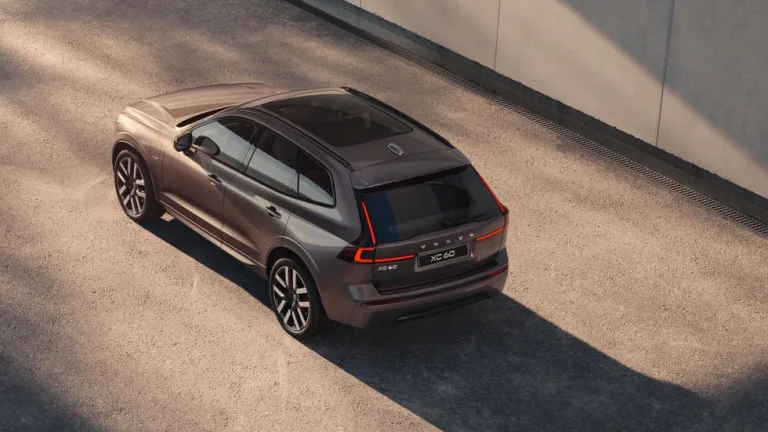 Image 8: A sleek SUV parked in a concrete environment with shadows and sunlight creating visual contrasts.