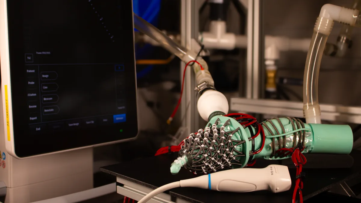 Image 41: Teal robot on a black table with cone-like attachment of spring coils.
